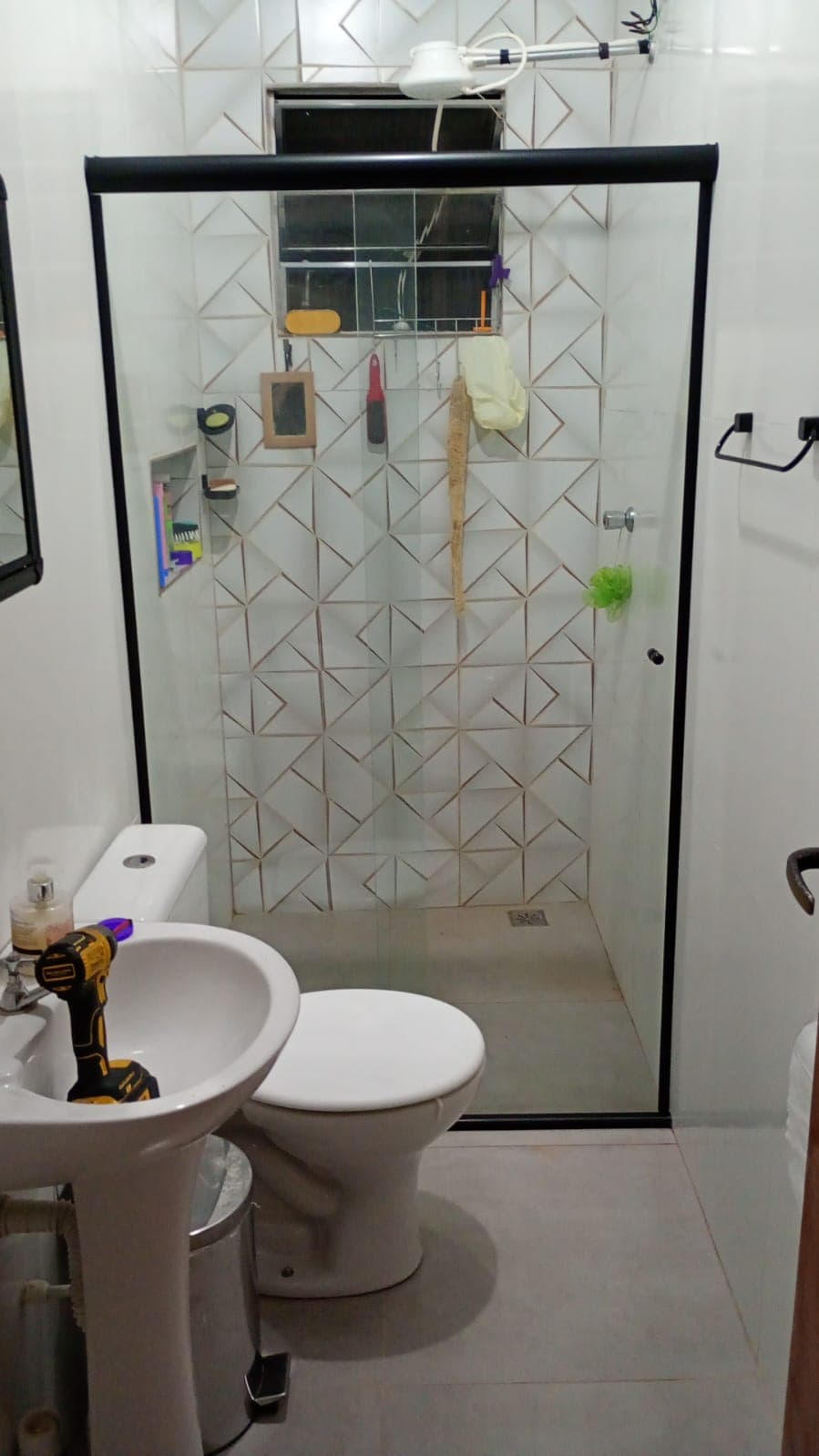 Box de banheiro com revestimento em pastilhas e porta de vidro preta