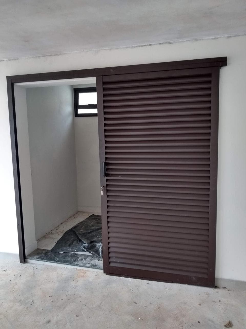 Porta de correr veneziana marrom em closet