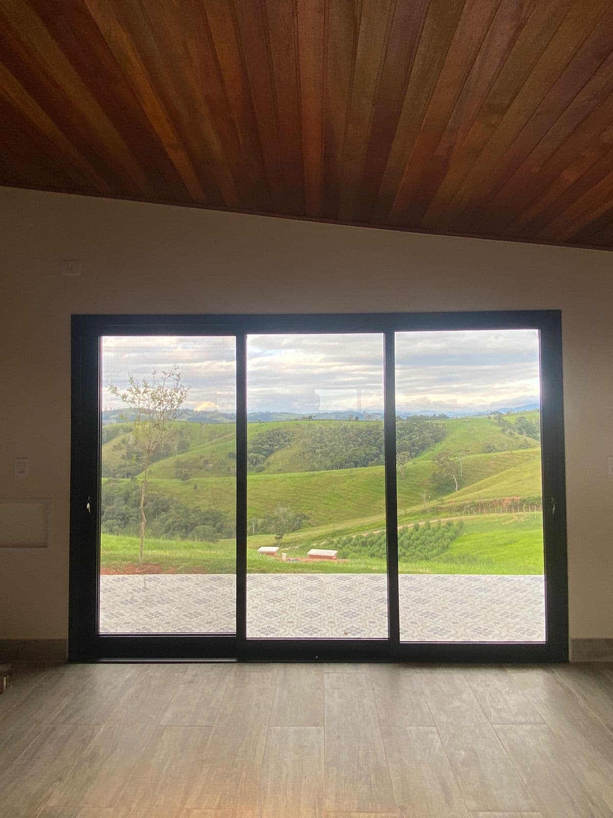 Janela de correr ampla com vista para paisagem verde