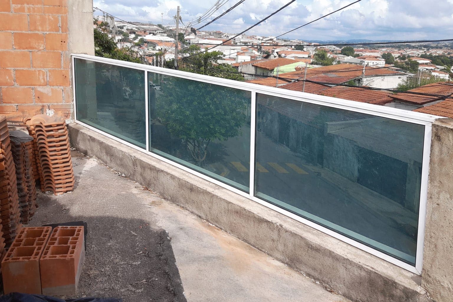 Fechamento de vidro em esquina de varanda com vista para a cidade